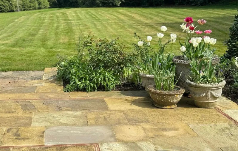 Grass lawn with paved area and plant pots